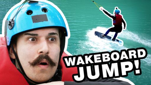 TikToker KeinPart2 in Schwimmweste und mit Helm schaut erschrocken. Neben ihm steht: Wakeboard Jump! Im Hintergrund sieht man ihn auf dem Wasser.