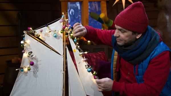 Juri schmückt ein Schiff mit Lichtern nach einer griechischen Tradition zu Weihnachten. | Rechte: KiKA/Josefine Liesfeld