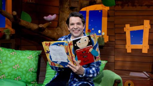 Rechte: KiKA Juri hält ein Kinderbuch in den Händen und liest darin.