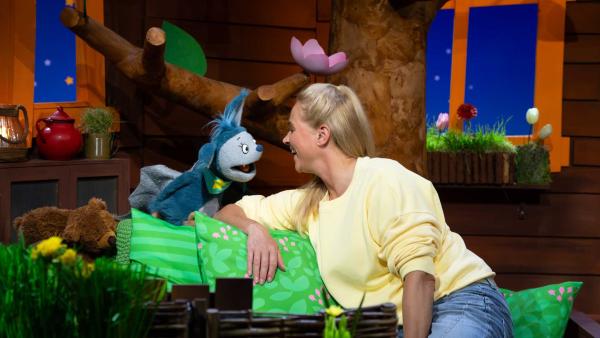 Singa und Fidi sitzen im Baumhaus und schauen sich lachend an.