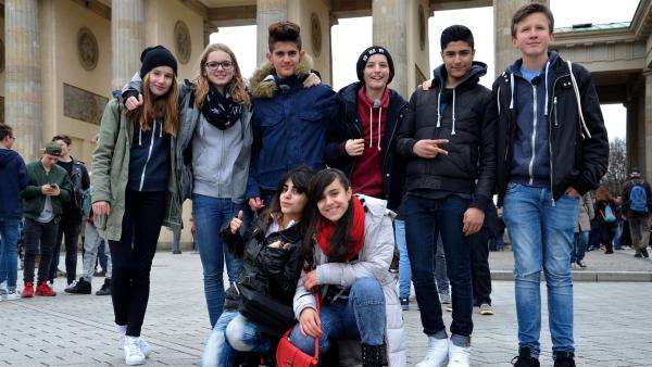 Die acht Jugendlichen haben sich gerade erst kennengelernt und wollen nun Berlin erobern. Sie fangen erstmal beim Brandenburger Tor an.  Spaß haben sie jetzt schon:  Malina, Millane, Akram, Linus, Seyid, Oscar (von links nach rechts, stehend),  Bayan und Rashad (vorne). | Rechte: ZDF/IMAGO TV