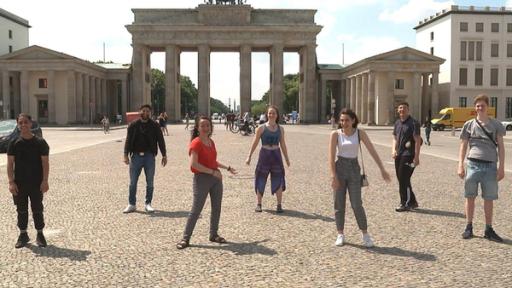 Die sieben von 'Berlin und wir! Spezial' vereint mit Abstand vor dem Brandenburger Tor. Die Jugendlichen haben gemeinsam die Prüfung zum Mofaführerschein absolviert. Dabei gab es Gelegenheit sich über Herausforderungen von Schulprüfungen zu unterhalten und das Leben als Geflüchtete in Berlin. (Hassan A., Seyid, Narges, Lilli, Manar, Hassan S., Aurel)