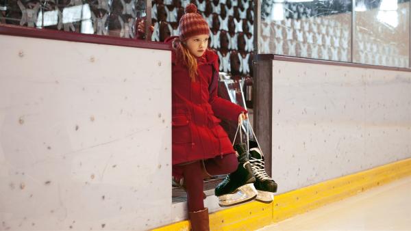 Auf der Suche nach Schuhen aus der Vergangenheit wagt sich Paule (Cloé Heinrich) zum ersten Mal seit langem wieder in die Eishalle. | Rechte: KiKA/WunderWerk/Britta Krehl