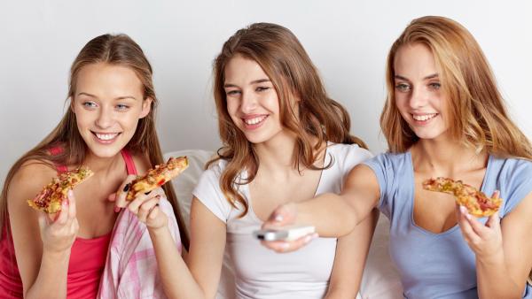 Drei Mädchen essen Pizza vor dem Fernseher | Rechte: colourbox.com
