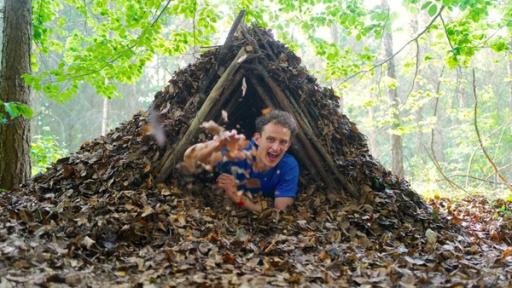 Überleben in der Natur | Checker Julian in einem selbstgebauten Unterschlupf.