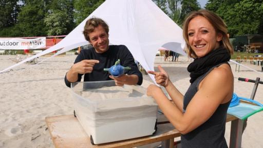 Sand flüssig machen?! / Tobi mit Beachvolleballerin Tatjana. Tobi soll den Fisch im Sand versinken lassen - ohne Graben und ohne Druck.