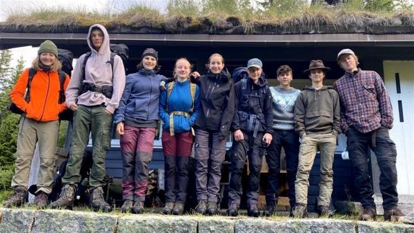 Von links nach rechts stehen Leyla, Max, Emilia, Kaja, Emma, Maxi, Ben aka Fritz, Niklas und Florentin in  Wanderoutfits.