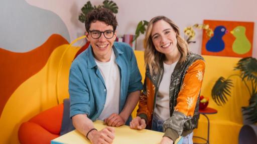 "Stärkste Themen, beste Szenen - Das Wunder DU": Melanie Flicker (r.) und Christoph Hirschler (l.) stehen hinter einem Tisch und lächeln in die Kamera.