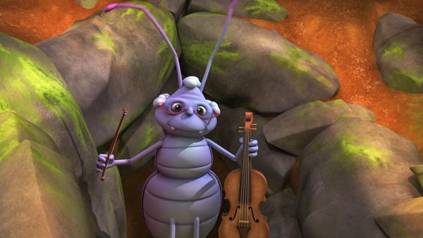 Käfer Stridularius hält eine Geige und einen Geigenbogen in den Händen. | Rechte: Nach Waldemar Bonsels “Die Biene Maja”. © 2012 Studio 100 Animation 