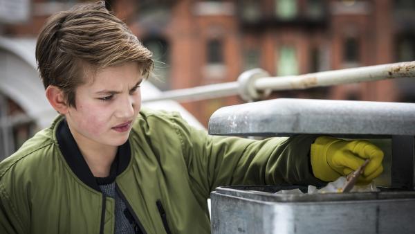 Johannes (Luke Matt Röntgen) durchsucht fieberhaft die Mülleimer in der Umgebung des Cafés nach Indizien. | Rechte: NDR/Boris Laewen