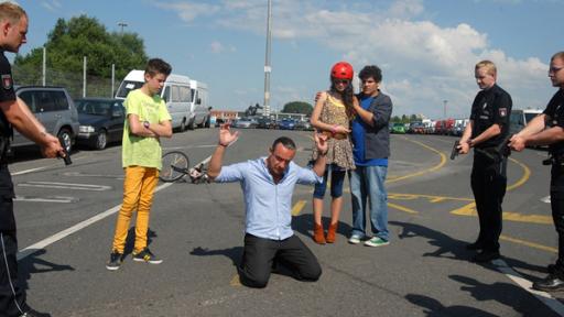 Der Munitionsschmuggler Thorsten Fricke (Tim Grobe)  wird von Polizisten gestellt. Die Pfefferkörner (von links nach rechts: Jaden Dreier, Merle de Villiers und Danilo Kamber) stehen dabei