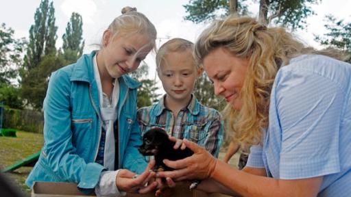 Sophie (Katherina Unger), Emma (Aurelia Stern) und die Tierärztin Frau Abraham mit einem Welpen.