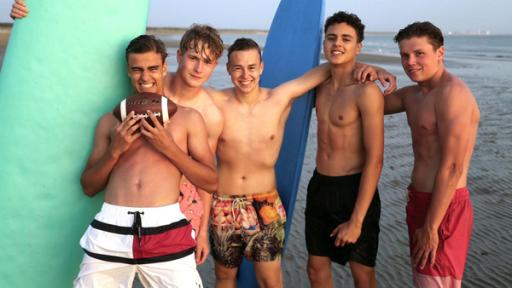 Luke, Mark, Alex, Ruben und Jeppe mit Surfbrettern am Strand