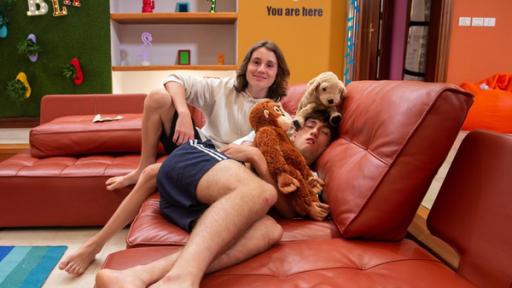 Leo und Adis liegen mit Kuscheltieren auf der Couch