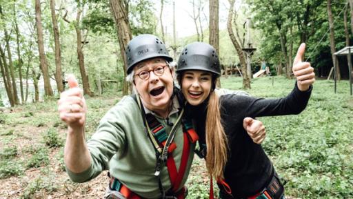 Hubert und Pia mit Helm im Kletterpark umarmen sich.