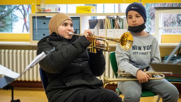 Rayan (l.) und einer weiterer Schüler von der Gemeinschaftsschule Campus Efeuweg erlernen beim Musikprojekt "Don't Stop the Music" Trompete zu spielen. Das Ziel der Kids: ein großes Abschlusskonzert. | Rechte: ZDF/Oliver Ziebe