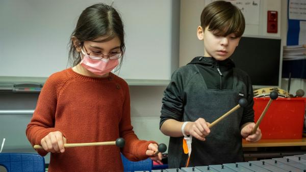 Cem (r.) und eine weitere Schülerin (l.) von der Gemeinschaftsschule Campus Efeuweg erlernen beim Musikprojekt "Don't Stop the Music" Percussion zu spielen. Das Ziel der Kids: ein großes Abschlusskonzert. | Rechte: ZDF/Oliver Ziebe