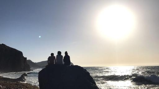 Die Jugendlichen genießen den Sonnenaufgang am Meer