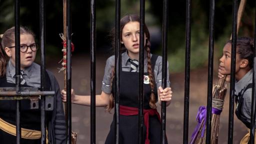 Maude, Mildred und Enid stehen mit ihren Besen in der Hand vor verschlossenen Toren der Akademie. Sie kommen nicht mehr rein.