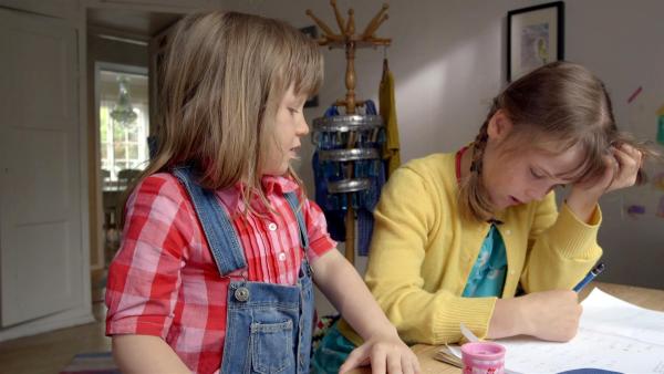 Elsa (Maya Anna Hansen Frølich) würde ihrer Schwester bei den Hausaufgaben gerne helfen. | Rechte: KiKA/NRK/Christine Heitmann