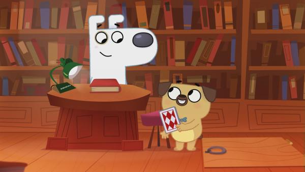 Dog und Puck stehen vor einem grpßen Bücherregal und grinsen sich an.
