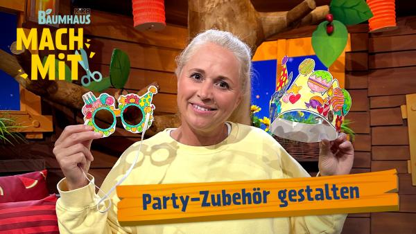 Eine blonde Frau (Singa) hält lächelnd eine bunte Partybrille und eine Partykrone nach oben. 