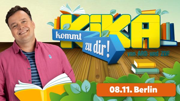 Auf der Grafik ist der Schriftzug "KiKA kommt zu dir!" mittig zu sehen. Links unten steht der Termin für die Vorlesezeit mit Christian: 08.11. in Berlin. Christian ist links im Bild zu sehen, er lächelt und hält ein aufgeblättertes Buch in den Händen.