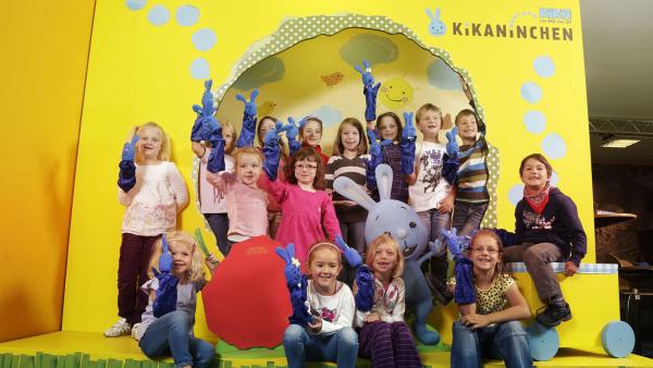 Eine Kindergruppe mit ihren selbstgebastelten Kikaninchen-Handpuppen.