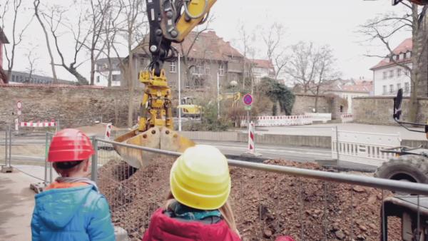 Zwei Kinder beobachten einen Bagger auf der Baustelle. | Rechte: KiKA