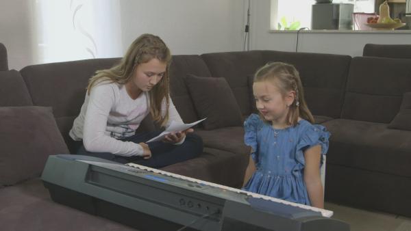 Viktoria liest eine Gespenstergeschichte vor. Emily begleitet sie dabei auf ihrem Keyboard. | Rechte: KiKA