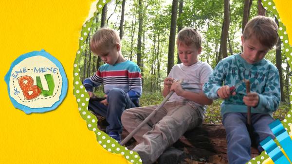 Kinder im Wald schnitzen Stöcke. 