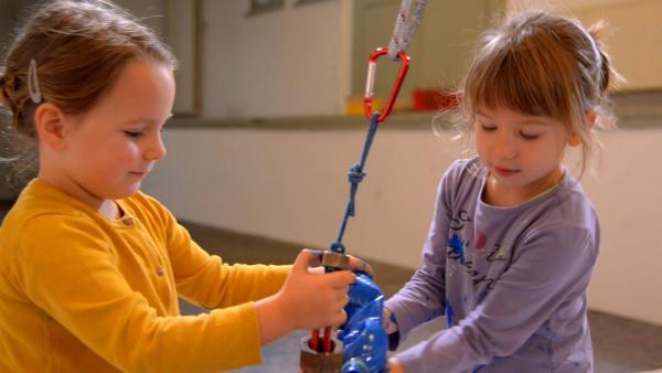 Emelie und Frida füllen Farbe in das Pendel. | Rechte: KiKA/Motion Works GmbH