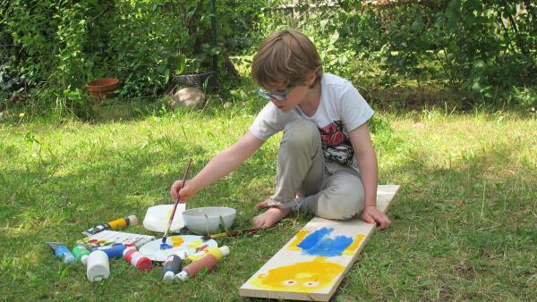 Liam malt auf Holz. | Rechte: KiKA/Motion Works GmbH