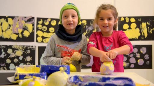 Maria und Luc drucken mit Farbe und Ballons.