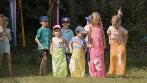 Kinder spielen Sackhüpfen.