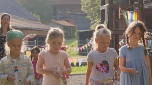 Vier Grundschulkinder stehen auf einer Wiese. Sie halten je einen Löffel mit einem Ei in den Händen.