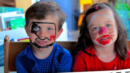 Zwei Kinder haben geschminkte Gesichter und zwei Jungs sind als Roboter und Ritter verkleidet.