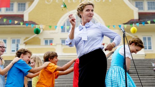 Frau Muthesius (Margarita Broich) feiert mit den Kindern das Abschiedsfest vom Sommercamp. | Rechte: SWR/Uschi Reich