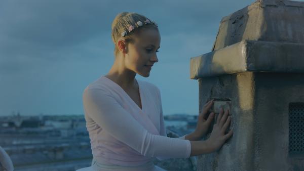Lena (Jessica Lord) wartet sehnsüchtig vor dem Schornstein auf dem Dach der Opéra Garnier auf einen Brief von Henri. | Rechte: ZDF/Cottonwood Media 2018