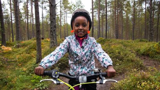 Mutig fährt Paola auf ihrem Mountainbike den Berg herunter.