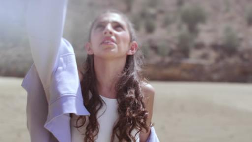 Maria Pissarides schaut in den Himmel, um sie herum eine Strandlandschaft