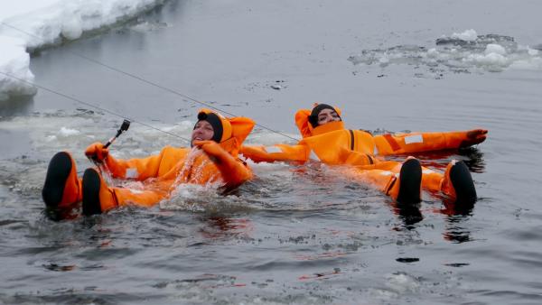 An Sicherungsleinen planschen die beiden fröhlich im eiskalten Wasser herum. | Rechte: KiKA/Stefanie Jung