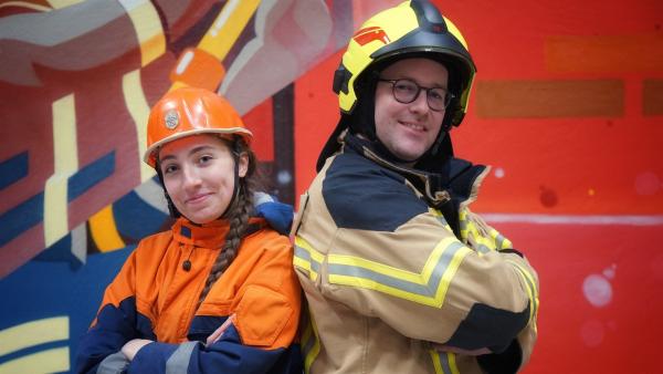 Ben besucht die Feuerwehrerlebniswelt in Augsburg. Dort zeigt ihm Feuerwehrmitglied Emilia, welche Eigenschaften ein Feuerwehrmann haben sollte, um Brände oder andere Katastrophen bekämpfen und Menschen helfen zu können. | Rechte: KiKA/Franziska Gruber