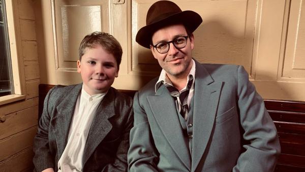 Ben und Julius sitzen kostümiert für eine historische Filmszene im Zug. | Rechte: KiKA/Eva Knäusl