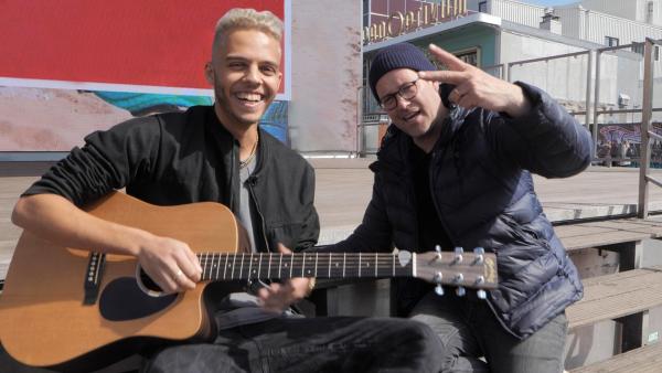 Beim Eurovision Song Contest steht Malik Harris für Deutschland auf der Bühne. Ben trifft ihn in Hamburg und testet, wie musikalisch Malik wirklich ist. | Rechte: KiKA