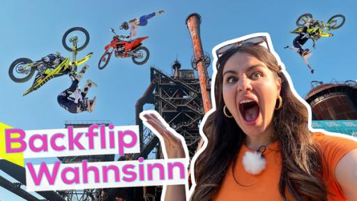 Vor dem Hintergrund der duisburger Industriekultur springen drei Personen mit ihrem BMX in akrobatischer Manier durch die Lüfte. Sarah ist erstaunt. Titel des Bildes: Backflip Wahnsinn.