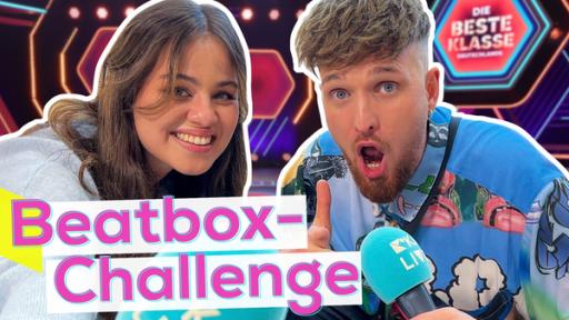 Relativ nah schauen Moderatorin Sarah und Beatboxer Madox mit Mikrofon freudig in die Kamera. Darunter der Schriftzug in Pink "Beatbox-Challenge", im Hintergrund das Studio von "Die beste Klasse Deutschlands".