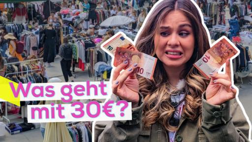 In der rechten Bildhälfte ist Sarah mit drei Zehn-Euro-Scheinen in den Händen. Sie schaut verwirrt und fragend auf die Scheine. Im Hintergrund ist ein großer Flohmarkt mit vielen Ständen. Aufschrift unten links: Was geht mit 30 Euro?