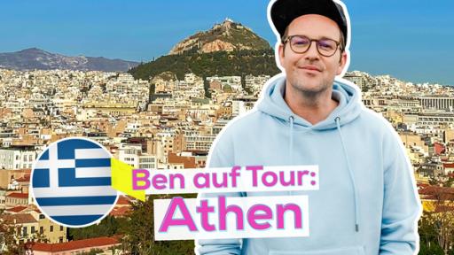 Ben steht mit freundlichem Blick vor der Stadtkulisse von Athen mit der Akropolis im Hintergrund. Unten eine Flagge Griechenlands und der Text: Ben auf Tour: Athen.