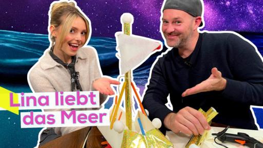 Lina Larissa Strahl und Ben sitzen um einen Basteltisch. Beide zeigen auf ein selbst gebasteltes Segelboot auf dem Tisch. Im Hintergrund ein Bild von einem Ozean mit Nachthimmel. Unten die Aufschrift Lina liebt das Meer.